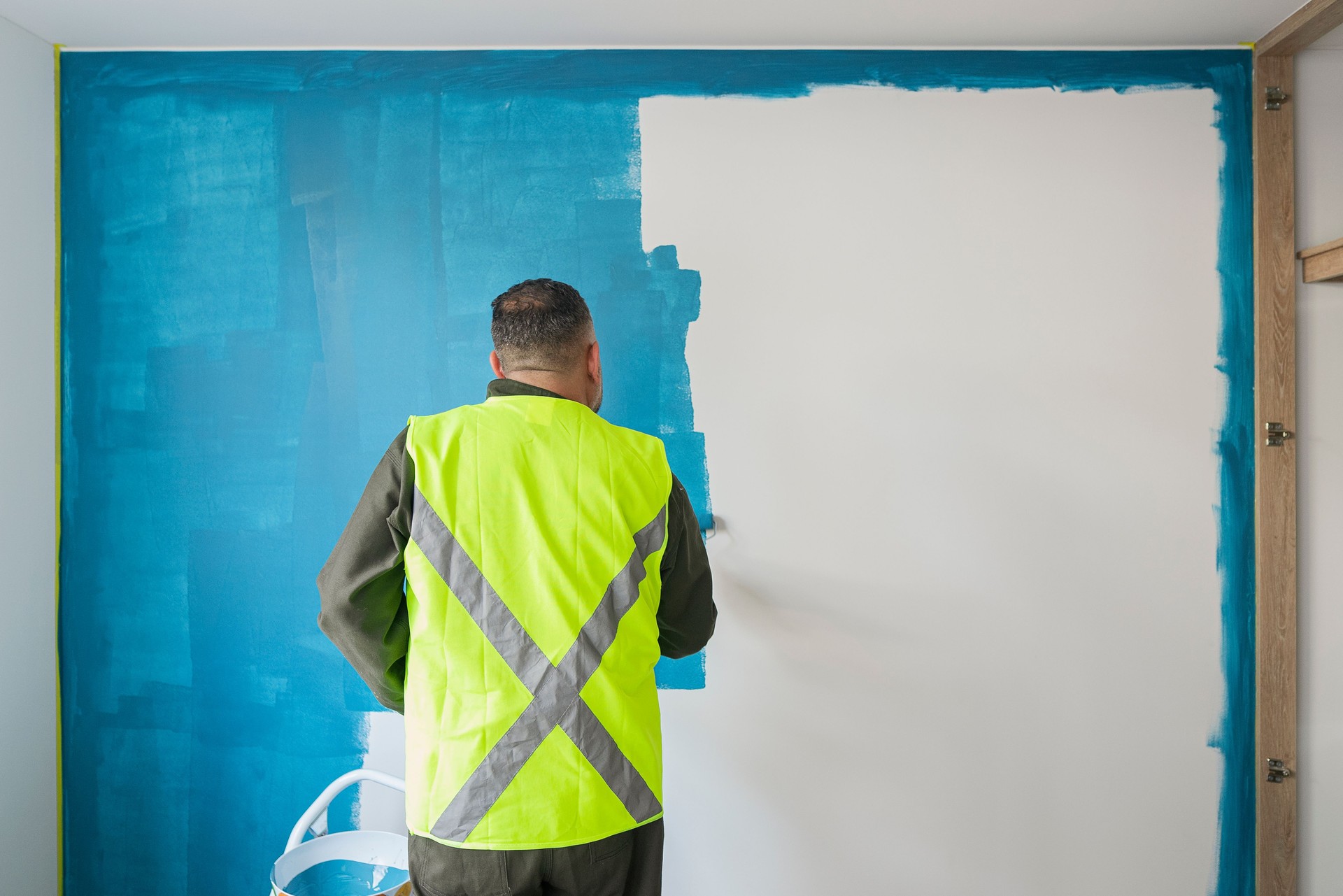 Worker paints the house yellow to hand it over to the new owners